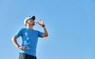 Man drinking to keep cool whilst exercising in heat.