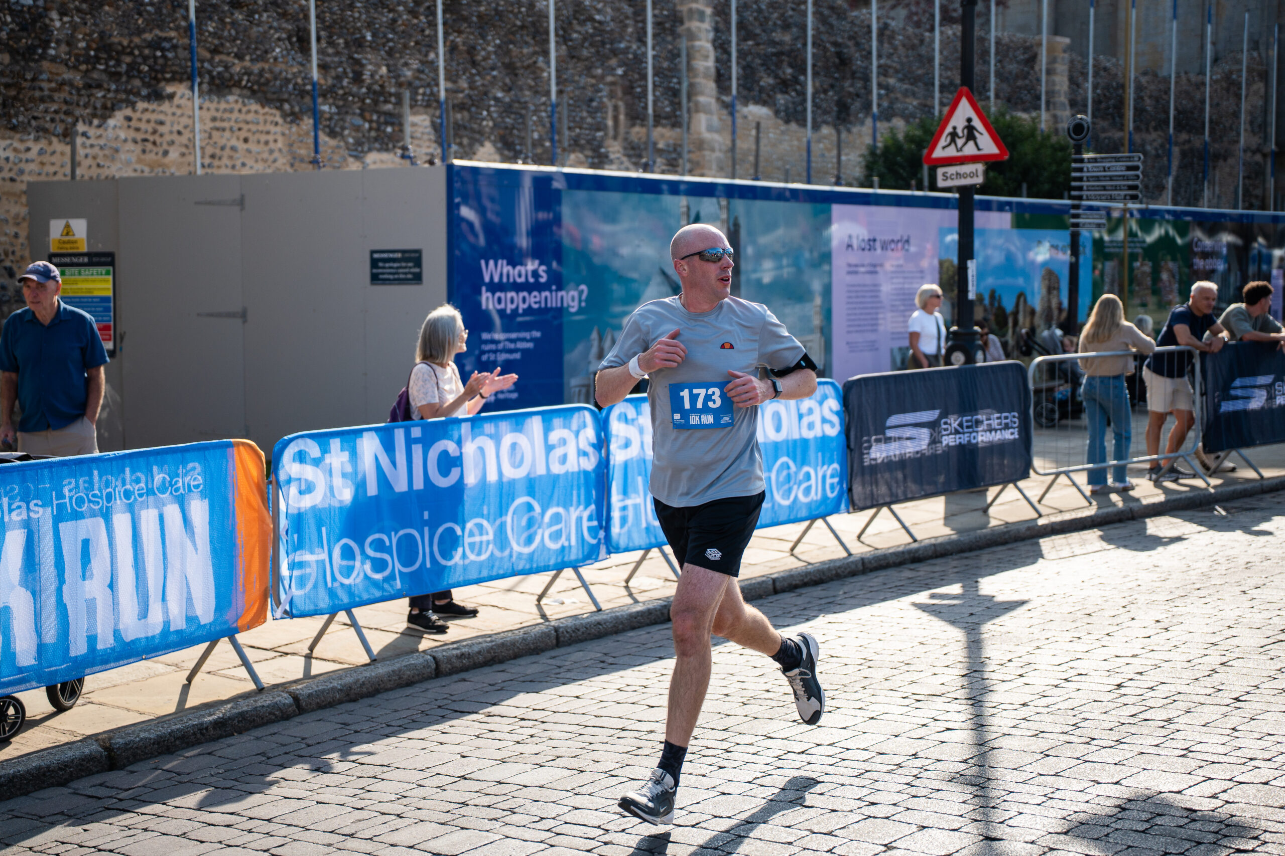 St Nicholas’ 10K Bury St Edmunds: Supporting Local Runners and Community Wellbeing Runner approaching the finish line at the St Nicholas' 10K in Bury St Edmunds.
