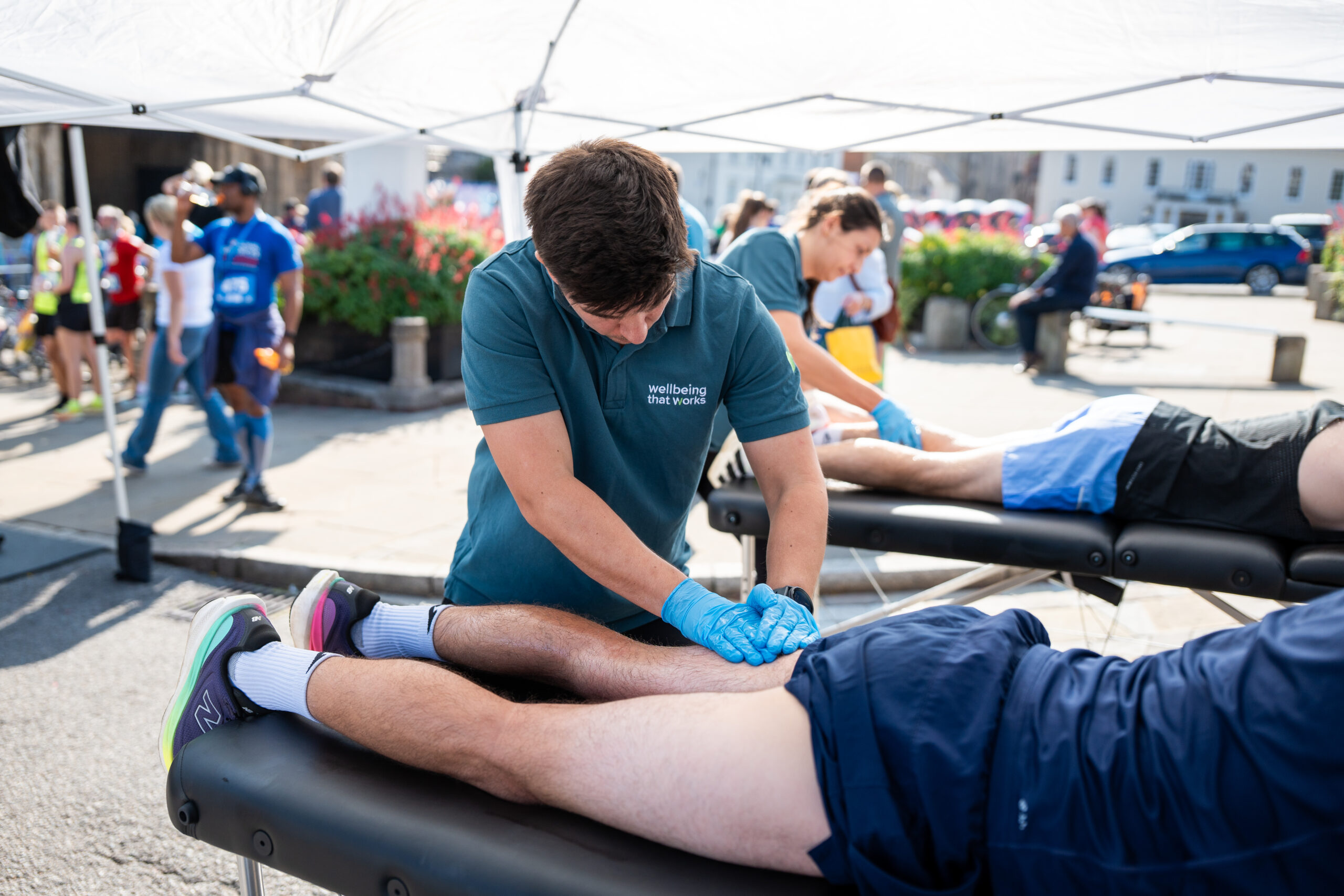 St Nicholas’ 10K Bury St Edmunds: Supporting Local Runners and Community Wellbeing Sports massage being provided to a runner after the St Nicholas' 10K.